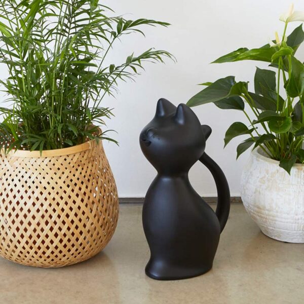 Annaffiatoio in plastica a forma di gatto nero, ambientato