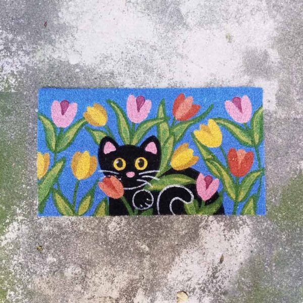 Zerbino con gattino nero fra i fiori